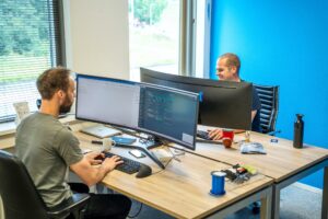 Rick en Bas achter hun computer bij Syntec